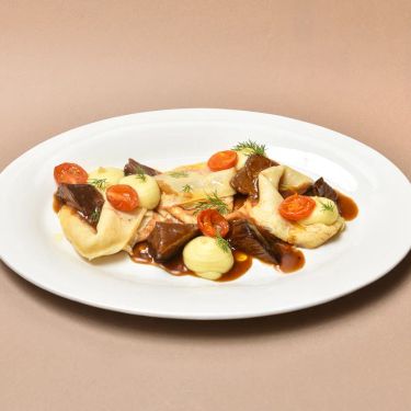 Баяу бұқтырылған шырынды бұзау еті мен хош иісті кептірілген қызанақтармен үйлескен, алтын түстес нәзік құймақтар.