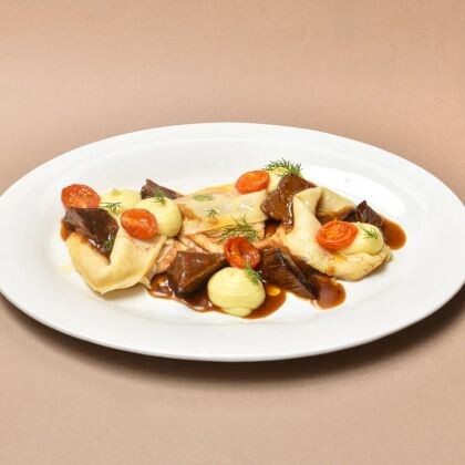 Баяу бұқтырылған шырынды бұзау еті мен хош иісті кептірілген қызанақтармен үйлескен, алтын түстес нәзік құймақтар.